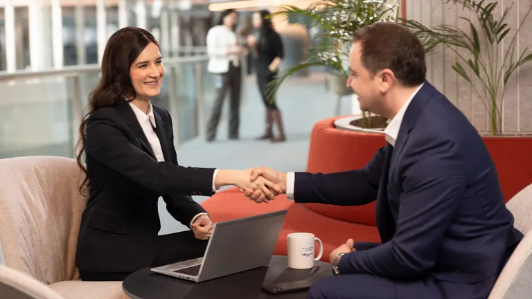 OMV Petrom male and female employees shake hands in an Petrom City setting, the OMV Petrom headquarters
